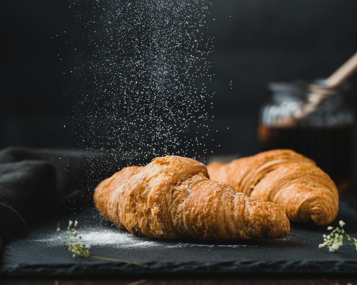 Croissants artisanaux dorés sur une plaque de cuisson