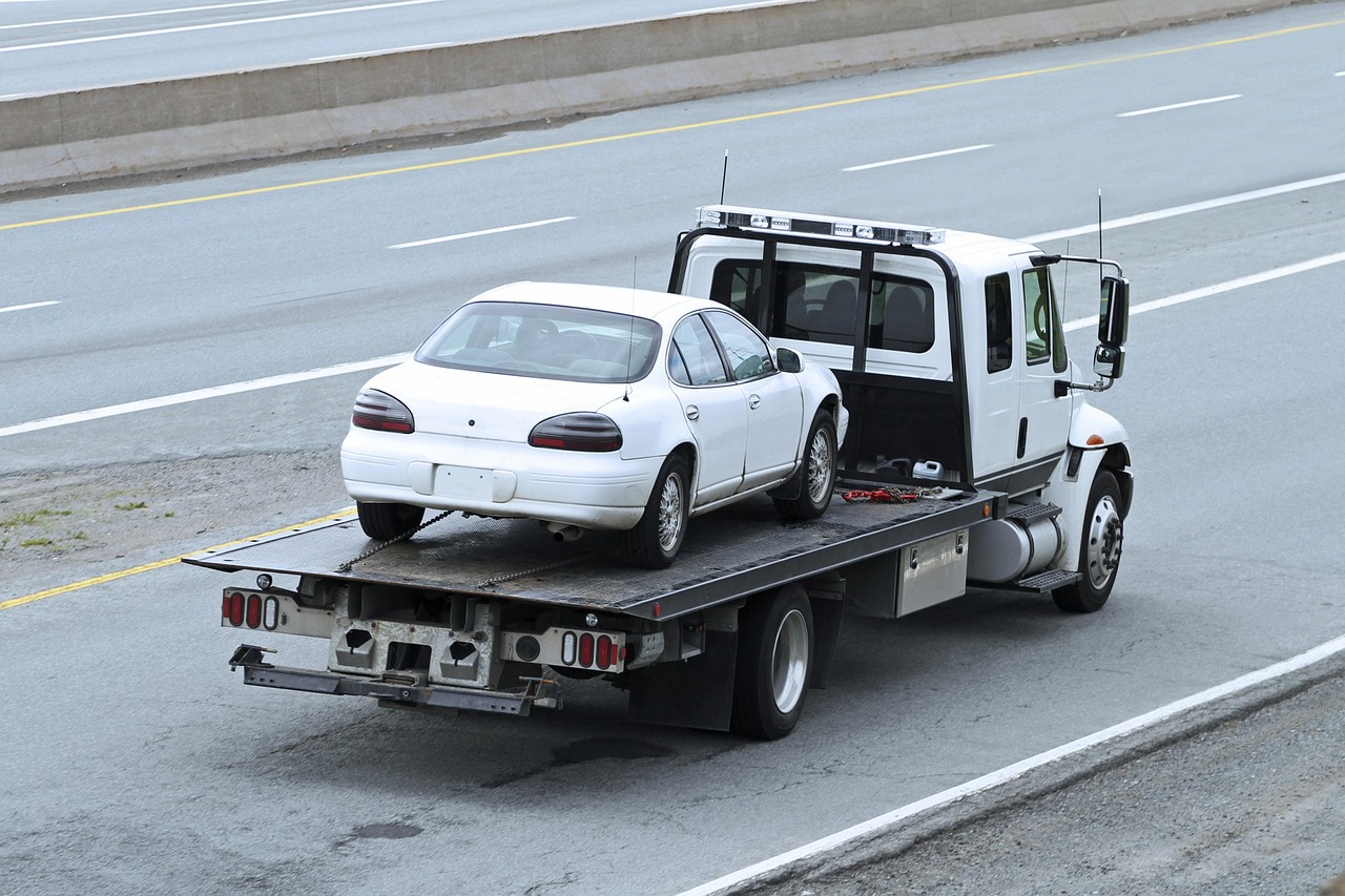 Véhicule de dépannage transportant une voiture sur plateau